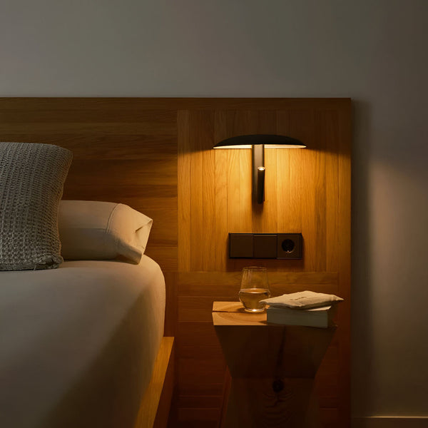 Unique wall light 360° adjustable ambient lighting in black steel for a cozy bedroom.