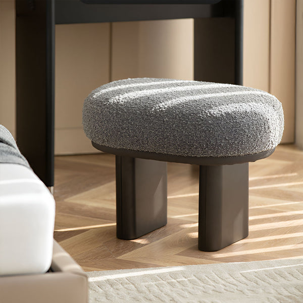 Stylish bouclé stool with oval seating and sturdy metal legs. Contemporary furniture. Leg Rest.